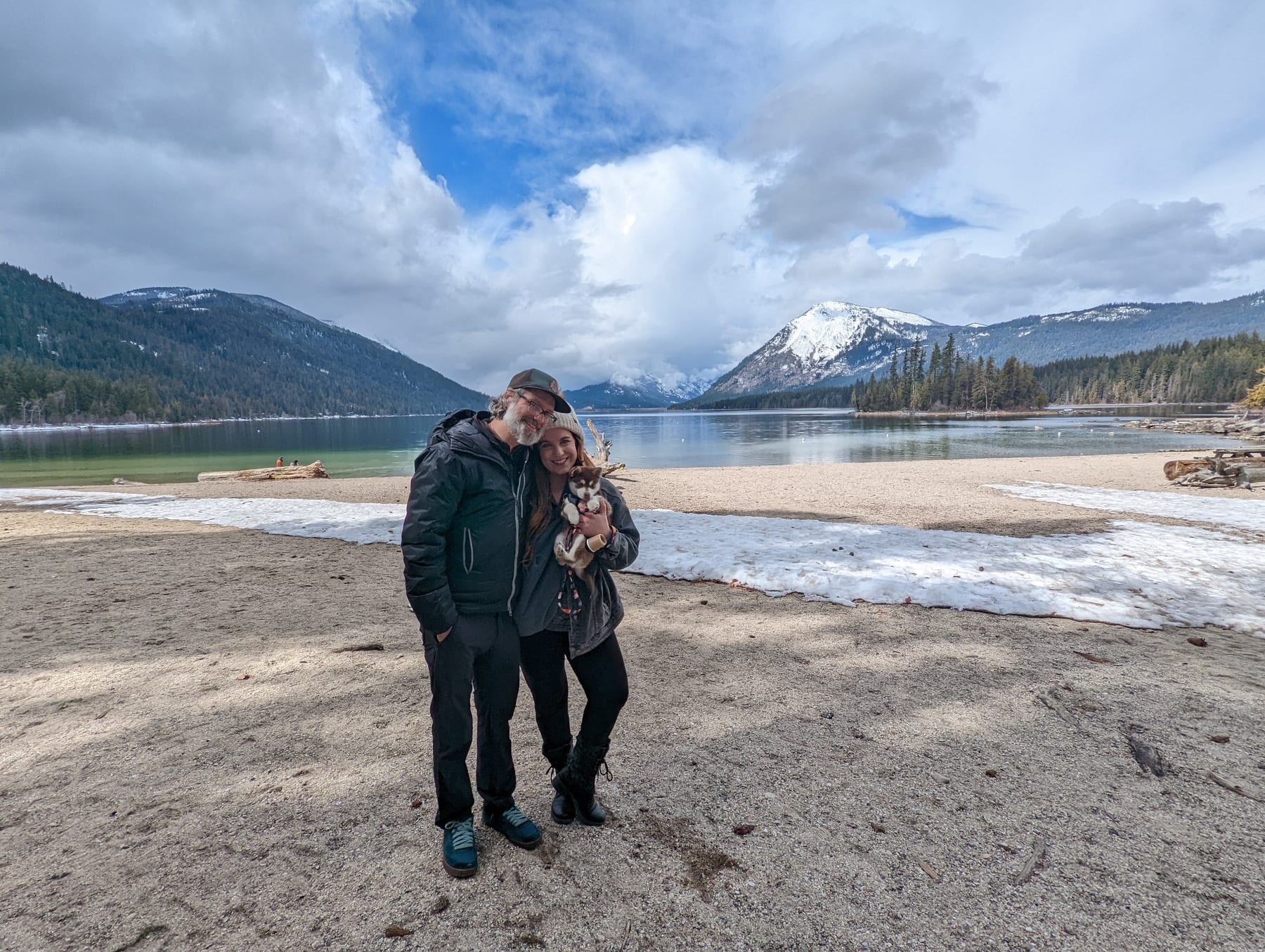 Steve and Nichole on a lakeshore beneath snowy mountains